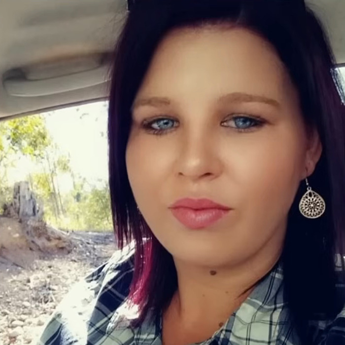 Young woman with blue eyes and earrings sitting inside a car near a rural area, related to teen mourner chasing hearse funeral.