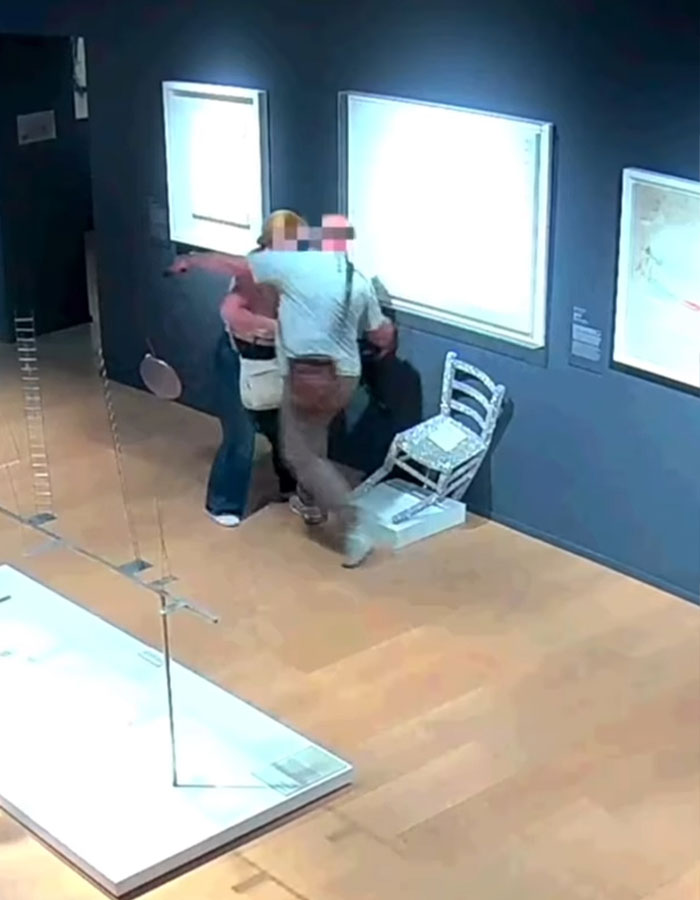 Tourist sits on crystal-covered Van Gogh chair in Italian gallery, causing it to break while others react nearby.