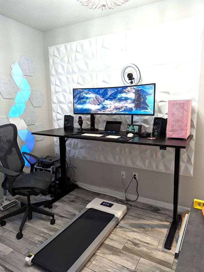 Modern home office setup with ergonomic chair, standing desk, ultra-wide monitor, and compact treadmill for everyday use under $300.