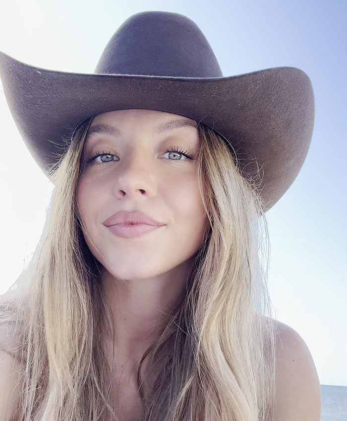 Sydney Sweeney wearing a wide-brimmed hat, posing confidently in a daring shoot by the ocean.
