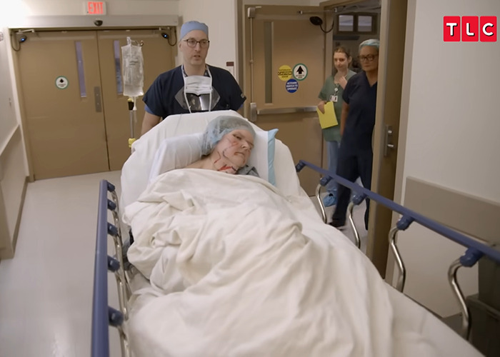 Patient from 1000-lb Sisters being wheeled on a gurney in hospital after a lengthy surgery with medical staff nearby. Patient from 1000-lb Sisters being wheeled on a gurney in hospital after a lengthy surgery with medical staff nearby.
