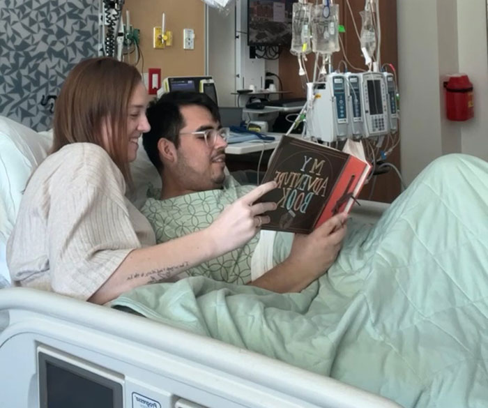 Tanner Martin in hospital bed reading a book with a woman, announcing his own passing in pre-recorded video. Tanner Martin in hospital bed reading a book with a woman, announcing his own passing in pre-recorded video.
