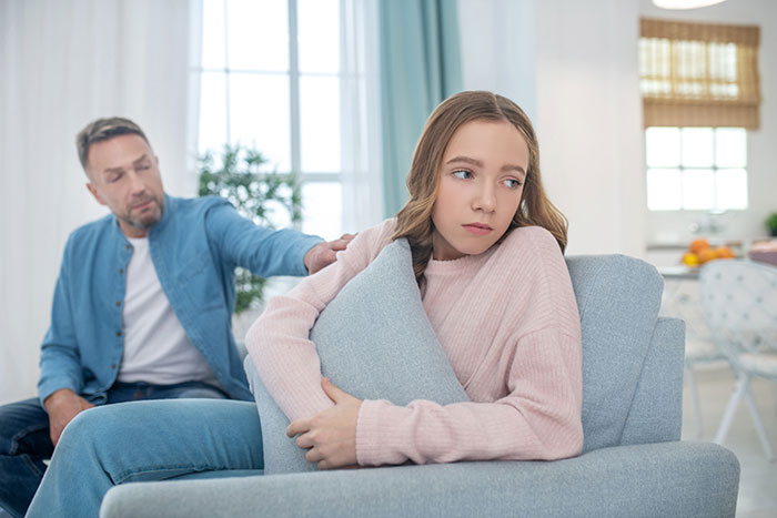 Father and daughter in a tense moment during a family vacation, highlighting business class upgrade causing conflict. Father and daughter in a tense moment during a family vacation, highlighting business class upgrade causing conflict.