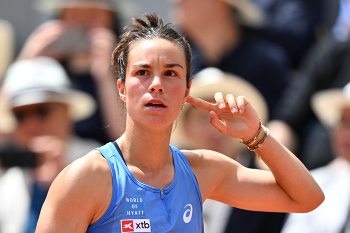 Tennis star reacting during a match after opponent&rsquo;s comment on her odor, wearing blue athletic gear on court.