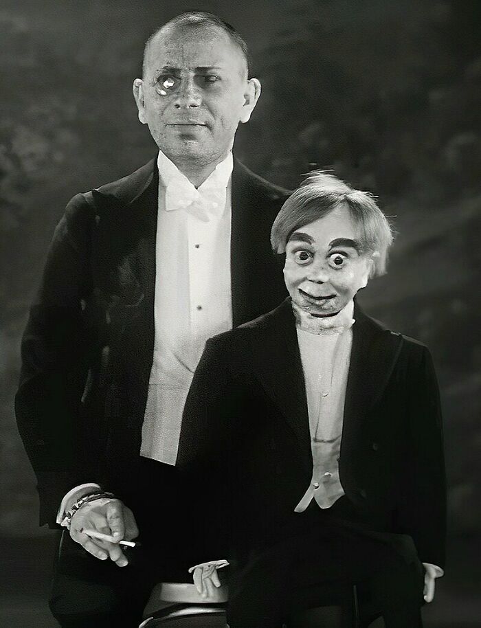 Black and white vintage photo of a man with a creepy ventriloquist dummy, both in formal attire, unsettling scene.