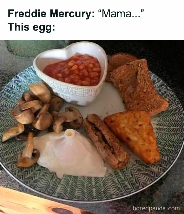 Disgusting food plate showing oddly cooked egg, baked beans in a heart-shaped bowl, mushrooms, toast, hash brown, and sausage.
