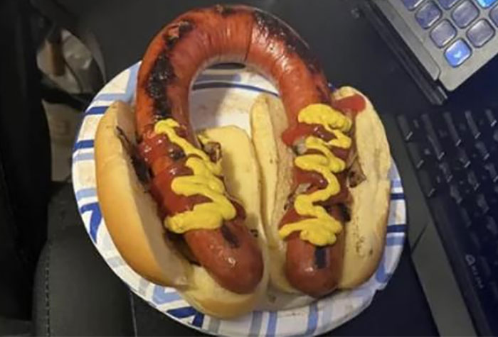 Two burnt and oddly shaped hot dogs with mustard and ketchup on buns, shown in disgusting food pics that might ruin appetite.
