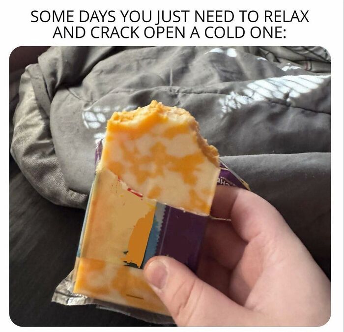 Hand holding a partially unwrapped block of cheese, a disgusting food pic that might ruin your appetite.
