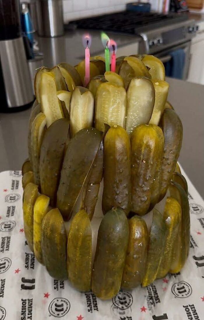 Pickle cake decorated with birthday candles, a disgusting food pic that might ruin your appetite in a kitchen setting.