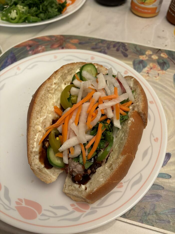 Sandwich with pickled vegetables, jalapeños, and sauce on a soft bun, part of disgusting food pics that might ruin appetite.