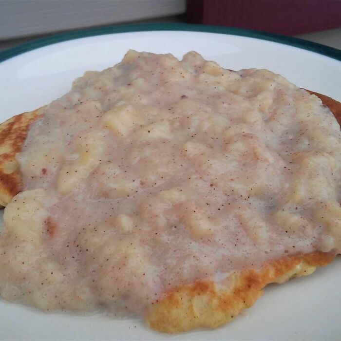 Close-up of a pancake covered with lumpy, unappetizing gravy, illustrating disgusting food pics that might ruin appetite.