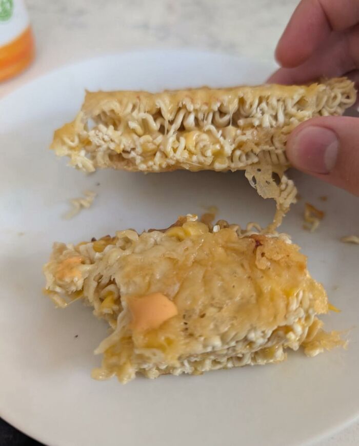 Close-up of a greasy, melted cheese and noodle food item that looks unappetizing in disgusting food pics.