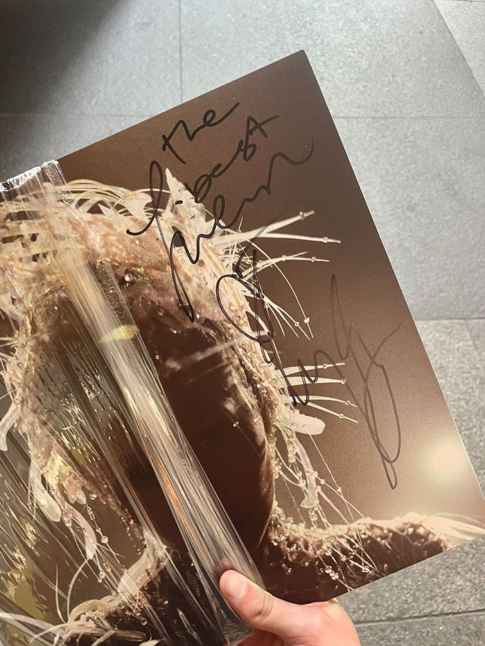 Signed album cover held in hand, featuring Miley Cyrus taking a jab at ex-husband Liam Hemsworth, sparking heated reactions. Signed album cover held in hand, featuring Miley Cyrus taking a jab at ex-husband Liam Hemsworth, sparking heated reactions.