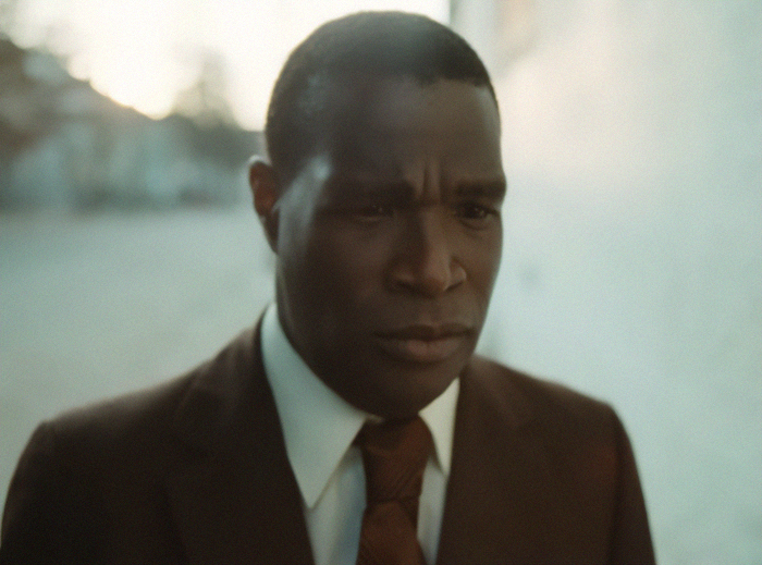 Man in brown suit and tie looking serious outdoors, unrelated to Michelle Obama or Malia dropping last name topic. Man in brown suit and tie looking serious outdoors, unrelated to Michelle Obama or Malia dropping last name topic.