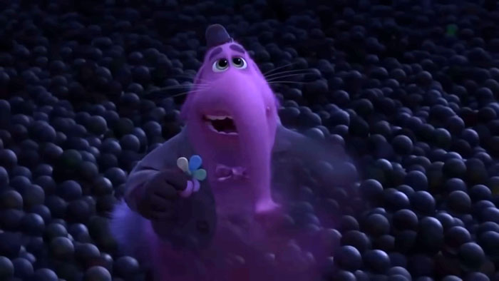 Character Bing Bong from Inside Out in a dark sphere-filled environment reacting emotionally, related to animated character deaths.