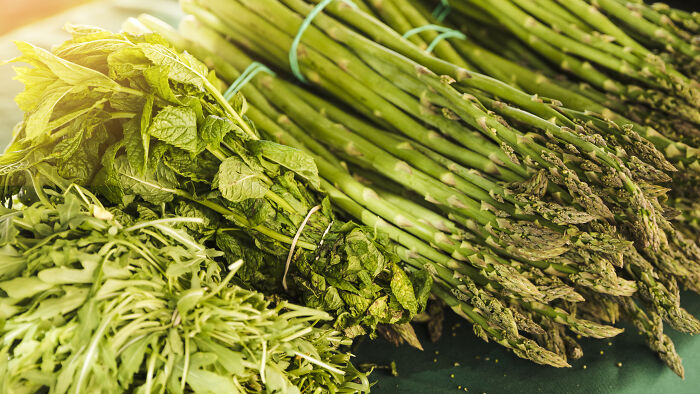 Fresh green vegetables including asparagus and leafy greens, illustrating things learned embarrassingly late about healthy eating.