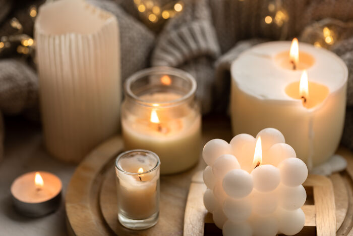 Assorted lit candles on a wooden tray creating a cozy atmosphere with warm lighting, symbolizing things learned embarrassingly late.