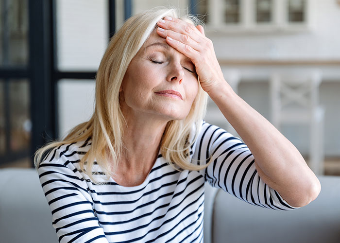 Middle-aged woman with blonde hair in striped shirt, expressing frustration about modern behaviors she can’t accept.