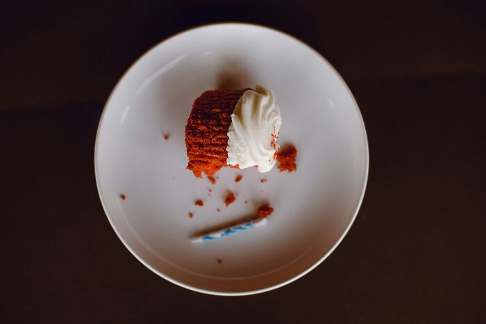 Half-eaten cupcake on a white plate symbolizing casual and harmless looking habits that may cause long term damage.
