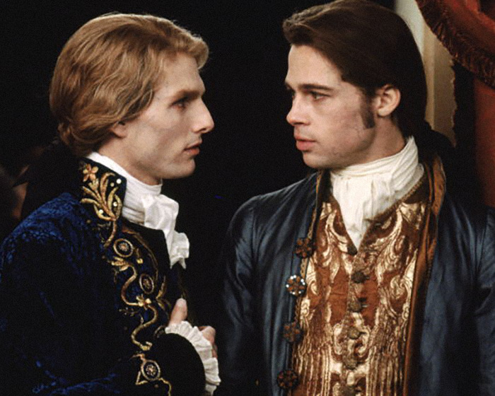 Two men dressed in ornate historical costumes, reflecting an 18th-century setting and style.