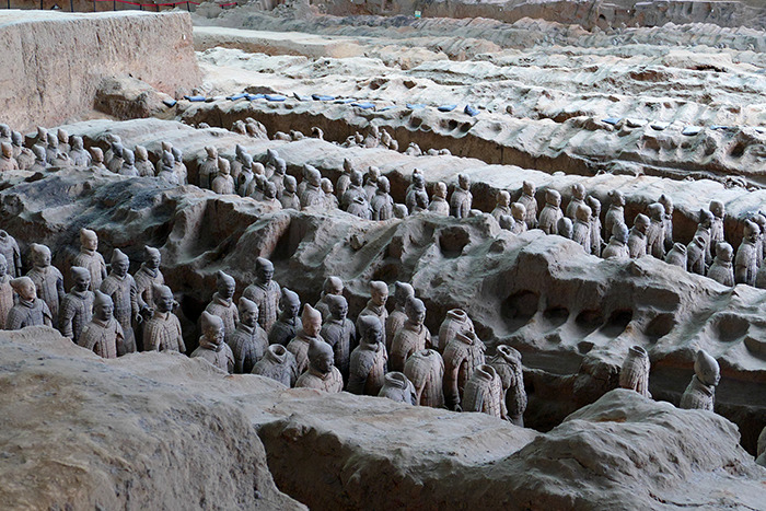 Terracotta army statues in an ancient pit showing 2000-year-old statues damaged by a tourist accident. Terracotta army statues in an ancient pit showing 2000-year-old statues damaged by a tourist accident.