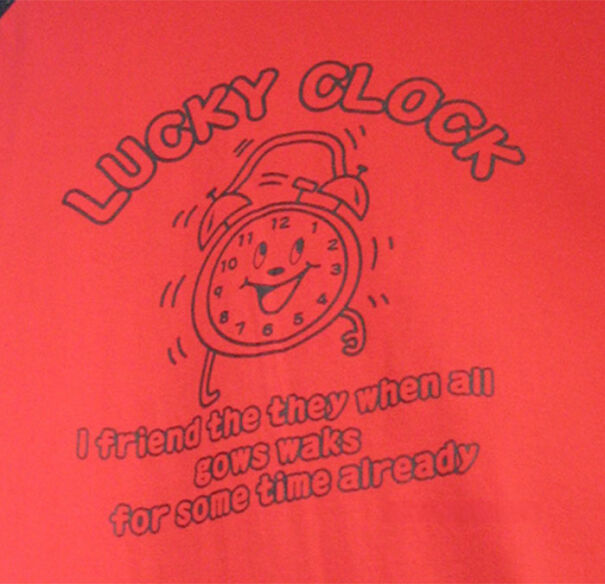 Red T-shirt with a cartoon clock and funny, baffling English text showcasing unusual language use and translation attempts.