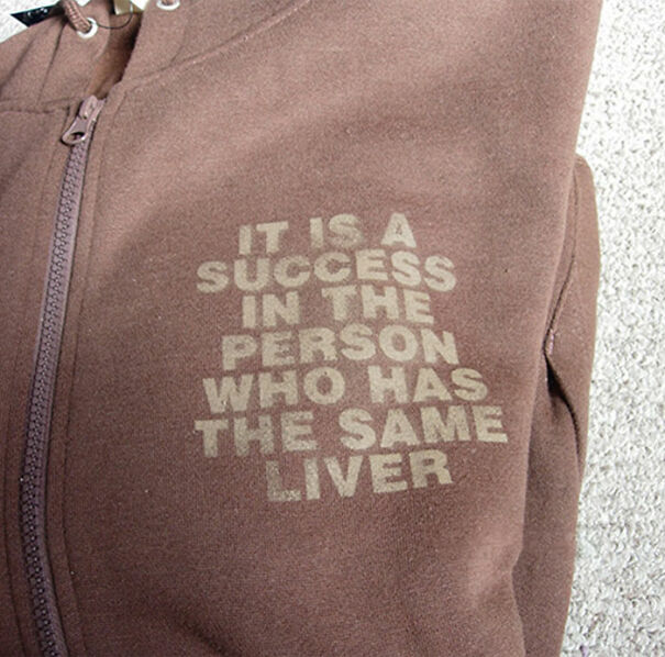 Brown hoodie with a confusing English phrase printed on the front, illustrating funny and baffling uses of English translations.