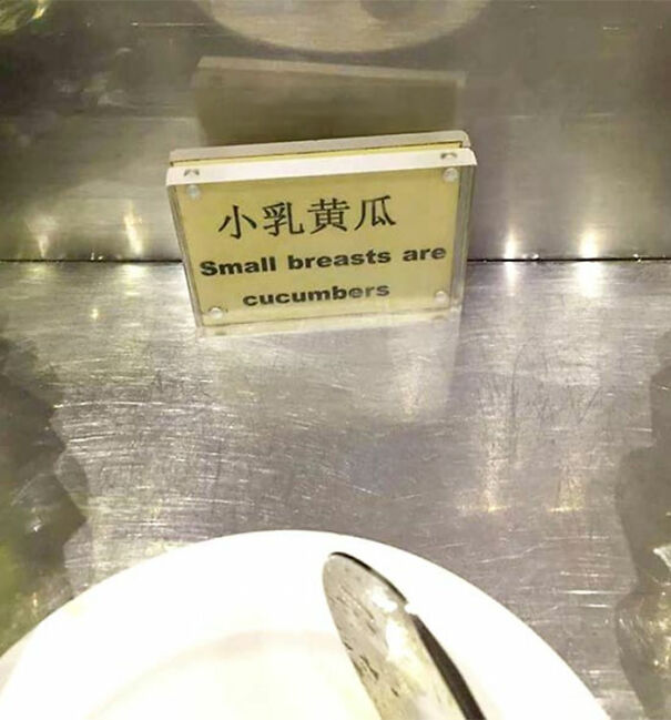 Funny and baffling uses of English shown on a mistranslated sign reading small breasts are cucumbers on a metal counter.