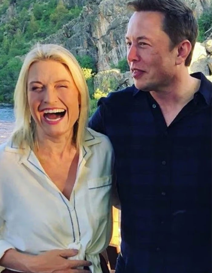 Elon Musk smiling and standing outdoors next to his sister, highlighting interest in her steamy romance service.
