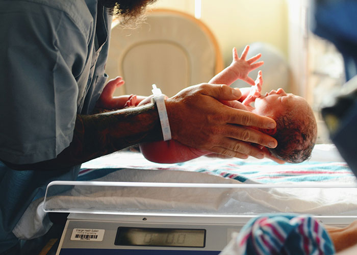 Newborn baby being weighed by tattooed parent, capturing unbelievable experiences people can prove to skeptics.