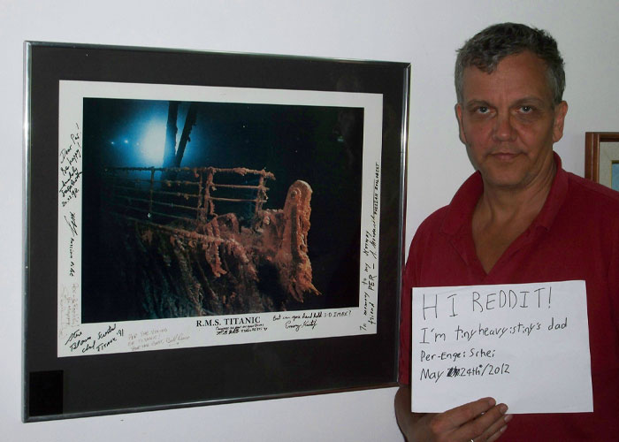 Man holding a sign next to a signed Titanic photo, sharing an unbelievable experience with proof for skeptics.