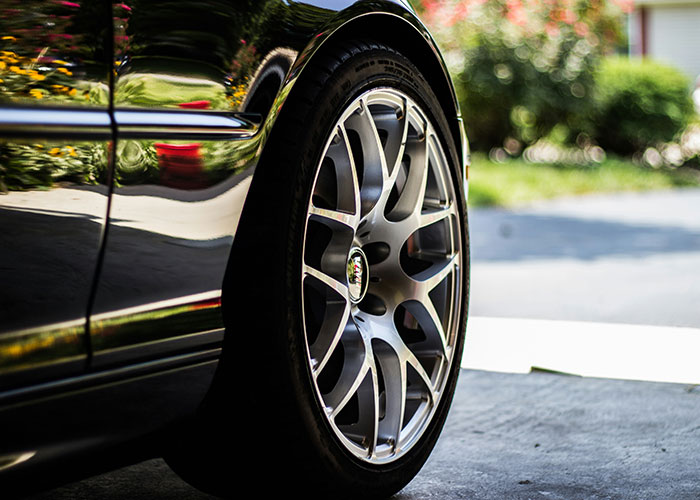 Close-up of a shiny car wheel reflecting surroundings, illustrating people share their most unbelievable experiences visual theme.