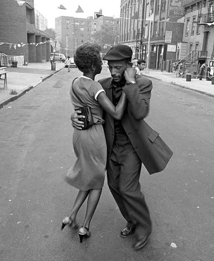 Rare historical photo of a couple dancing passionately on a city street, capturing a timeless moment of joy and connection.