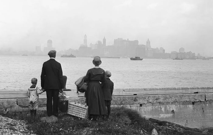 Family with luggage overlooking a foggy city skyline in a rare historical photo capturing a moment from the past.
