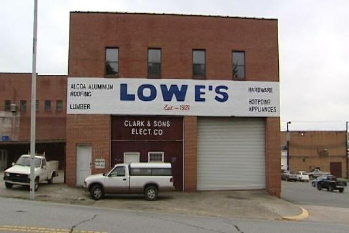 Old Lowe's hardware store building with pickup trucks parked outside, a rare historical photo capturing a moment in time.