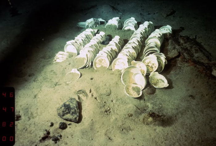 Underwater archaeological site with rare historical photos of ancient artifacts and seashells on the ocean floor