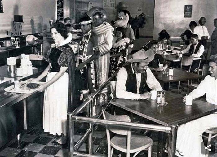 Rare historical photo of people in vintage costumes waiting in line at a diner, capturing a unique moment from the past.
