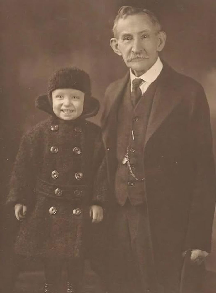 Vintage rare historical photo of an elderly man and smiling child dressed in early 20th century winter clothing.