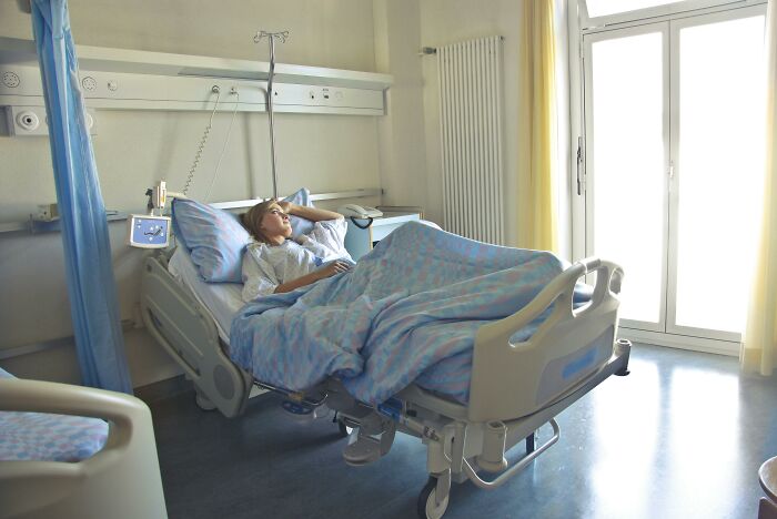 Person resting in a hospital bed in a bright room, depicting the concept of unethical life hacks for real world success.