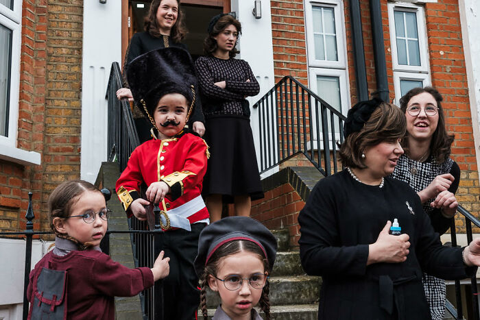 Children and adults in colorful costumes in a candid street photo capturing vibrant life moments outdoors