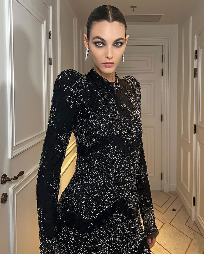 Leonardo DiCaprio's girlfriend wearing a sparkly black dress with bold makeup at a high-profile wedding event. Leonardo DiCaprio's girlfriend wearing a sparkly black dress with bold makeup at a high-profile wedding event.