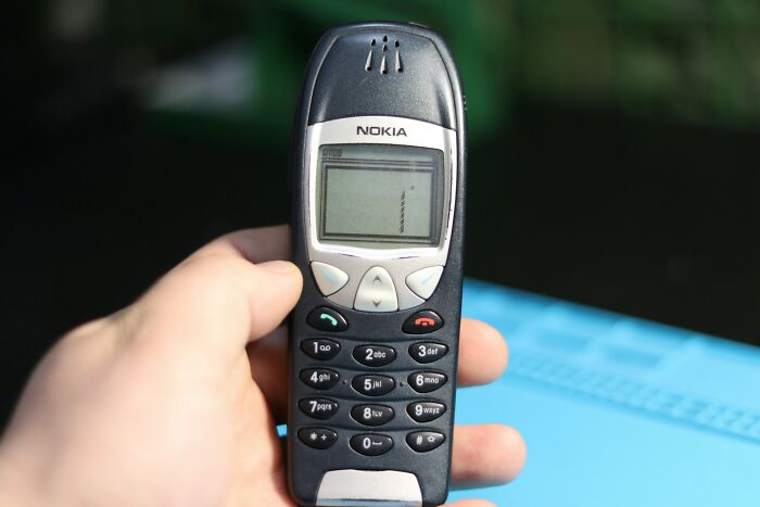 Hand holding a classic Nokia phone, symbolizing childhood joys before smartphones changed how life is recorded.