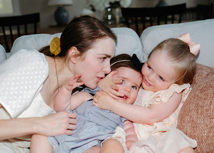 Woman and two children showing affection on a couch, illustrating microfeminism countering toxic masculinity concepts.