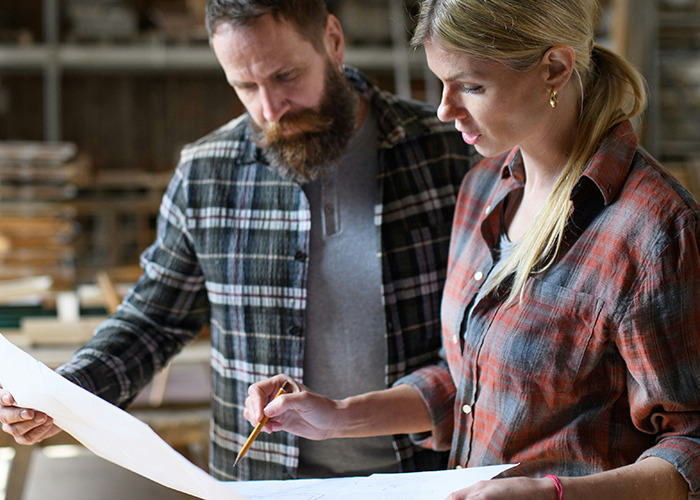 Woman and man reviewing plans together, illustrating collaboration and microfeminism to counter toxic masculinity in a work setting.