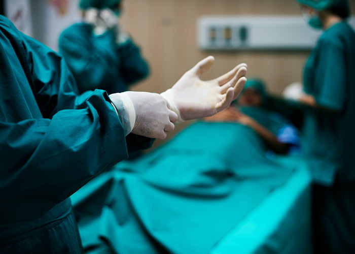 Medical professionals in surgical attire preparing in an operating room, highlighting microfeminism to counter toxic masculinity.
