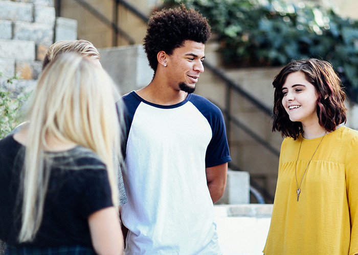 A diverse group of young people casually talking outdoors, highlighting microfeminism against toxic masculinity.