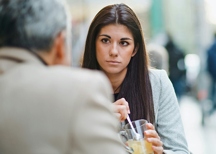 Young woman practicing microfeminism in a serious conversation as a way to counter toxic masculinity in a public setting.