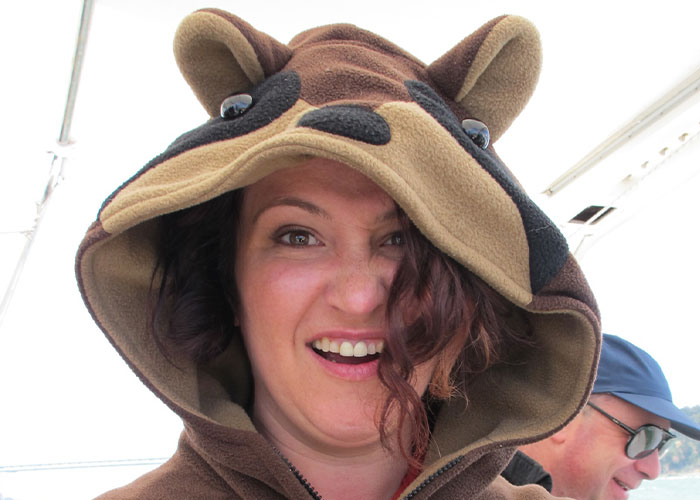 Woman wearing a bear costume hoodie with a surprised expression, illustrating weird and random moments caught on security tape.
