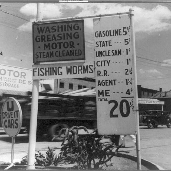 Vintage black and white photo showing historical gasoline prices and signs about motor services and fishing worms.