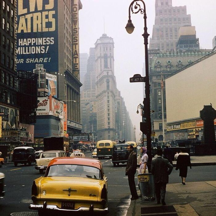 Vintage New York City street scene with classic cars and pedestrians, illustrating weird things about history.